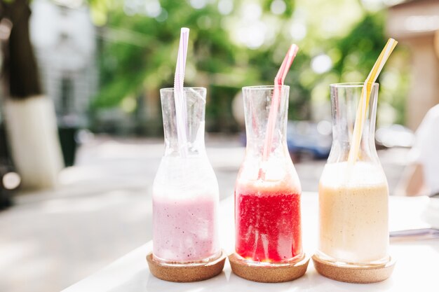 Foto exterior de tres botellas de sabrosos cócteles de frutas