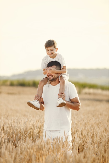 Foto de una familia joven en el campo de girasoles en un día soleado.