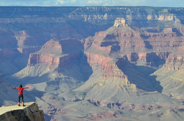 Foto fascinante de un turista mirando el Gran Cañón de Colorado, desde el borde sur, Arizona