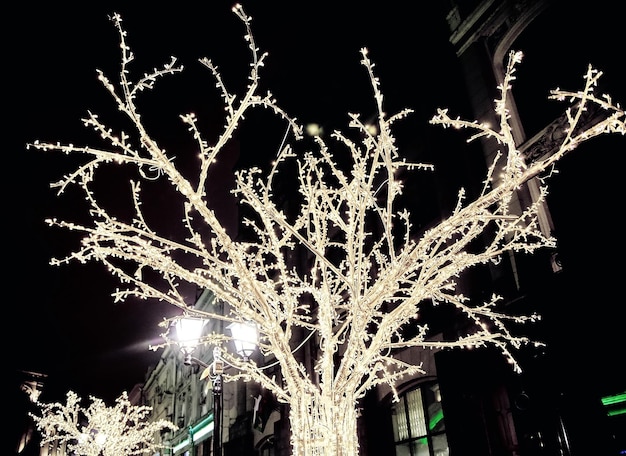 Foto del fondo de la calle en la noche nevada con luces navideñas