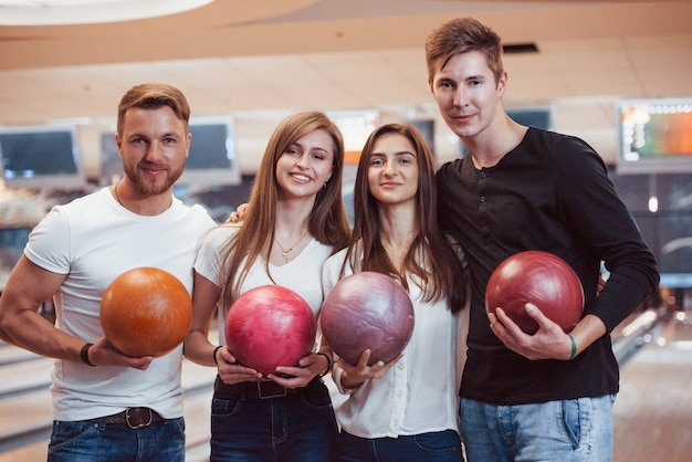 Foto de gente bonita antes del partido. Jóvenes amigos alegres se divierten en el club de bolos en sus fines de semana