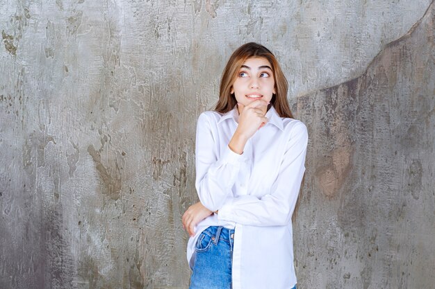 Foto de hermosa mujer de pelo largo en blusa blanca posando