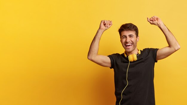 Foto de hombre caucásico alegre levanta la mano con triunfo