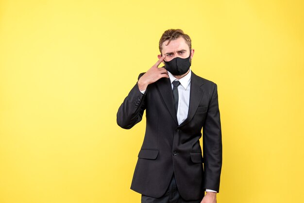 Foto de hombre joven con expresión facial confusa mientras está parado en el amarillo