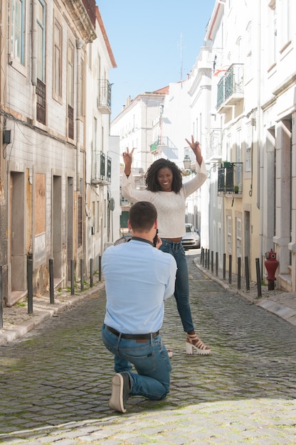 Foto de hombre tomando de juguetona mujer negra al aire libre