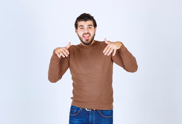 Foto de un joven atractivo modelo de pie y posando sobre una pared blanca. Foto de alta calidad