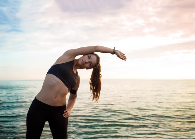 Foto de joven bella mujer fitness hace ejercicios deportivos