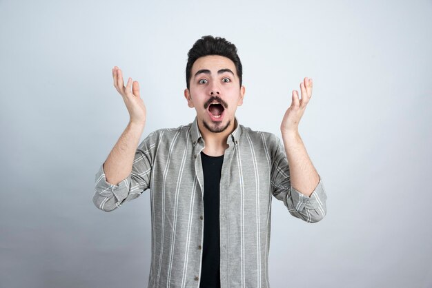 Foto de joven guapo con barba de pie y posando.