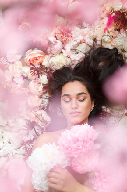 Una foto de una joven modelo con un montón de flores. Foto de alta calidad.