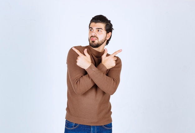 Foto de un joven modelo de pie y apareciendo con las manos. Foto de alta calidad