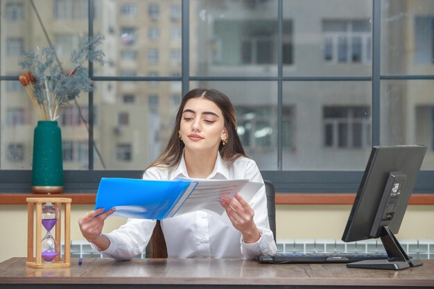 Foto de una joven sosteniendo un cuaderno y leyendo sus notas