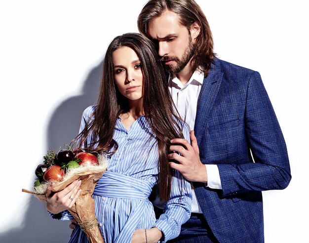 Foto de moda de hombre elegante guapo en traje con hermosa mujer sexy en colorido vestido en blanco