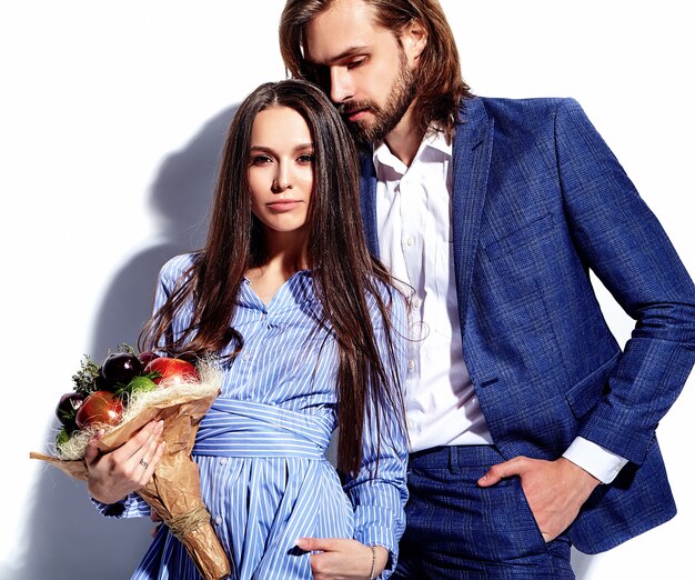 Foto de moda de hombre elegante guapo en traje con hermosa mujer sexy en colorido vestido en blanco