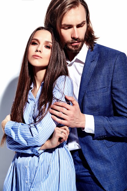 Foto de moda de hombre elegante guapo en traje con hermosa mujer sexy en colorido vestido en blanco