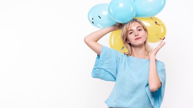 Foto de moda mujer sosteniendo globos encima de la cabeza