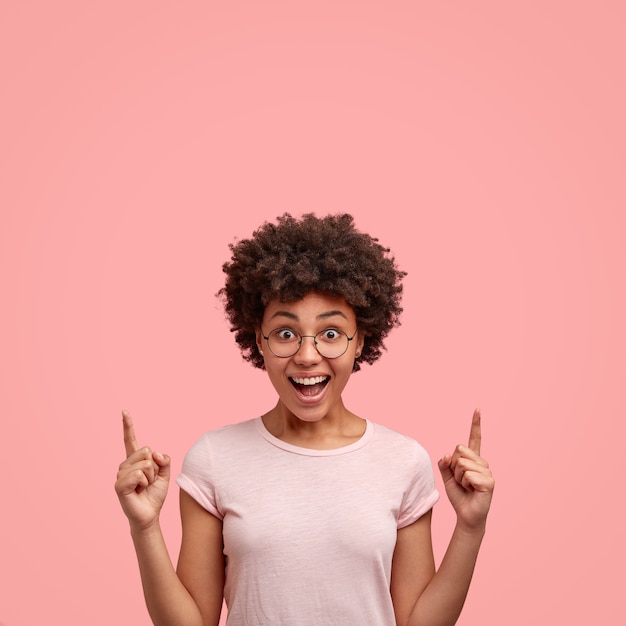 Foto de mujer alegre impresionada con corte de pelo afro