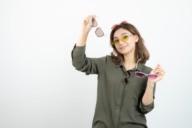 Foto de mujer hermosa con gafas de sol de colores sobre blanco. foto de alta calidad