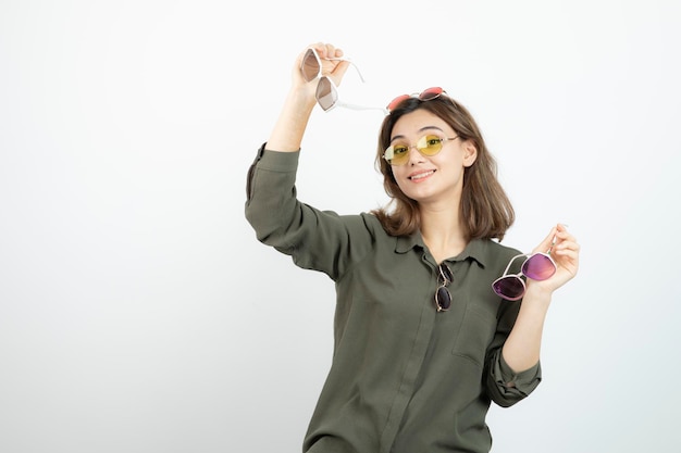 Foto de mujer hermosa con gafas de sol de colores sobre blanco. foto de alta calidad