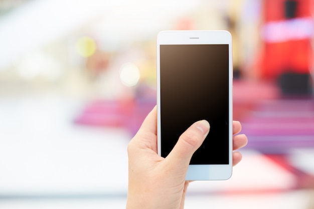 Foto de mujer irreconocible tiene teléfono inteligente moderno con pantalla en blanco copia en negro