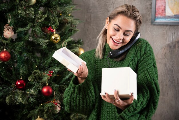 Foto de mujer joven hablando por teléfono y tiene expresión feliz