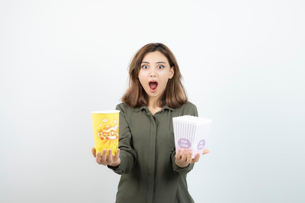 Foto de una mujer joven con ropa informal sosteniendo palomitas de maíz. foto de alta calidad