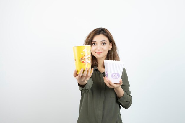 Foto de una mujer joven con ropa informal sosteniendo palomitas de maíz. foto de alta calidad