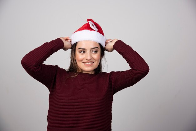 Foto de mujer joven con sombrero de Navidad posando.