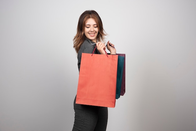 Foto de mujer joven sosteniendo bolsas de la compra.