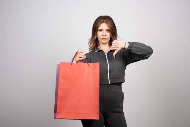 Foto de mujer joven sosteniendo bolsas de la compra.