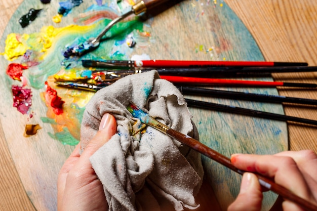 Foto de mujer mezclando pinturas al óleo sobre paleta de cerca