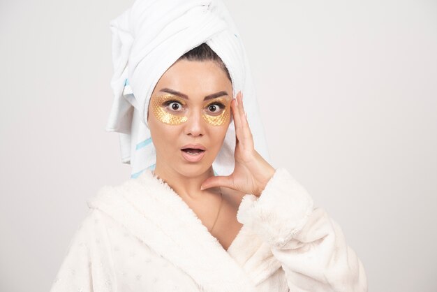 Foto de una mujer con parches de hidrogel en los ojos.