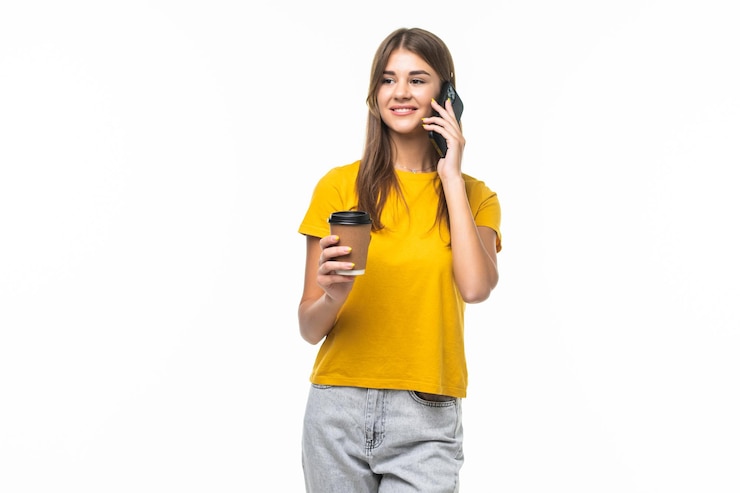 Foto gratuito foto de mujer de pie con smartphone y café para llevar en manos aisladas en gris