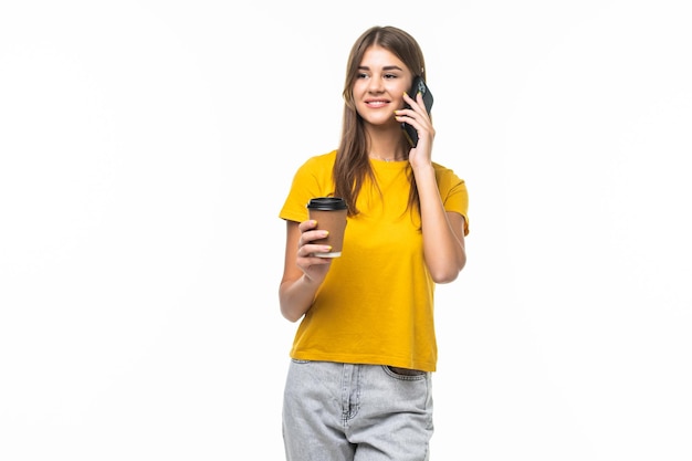 Foto de mujer de pie con smartphone y café para llevar en manos aisladas en gris