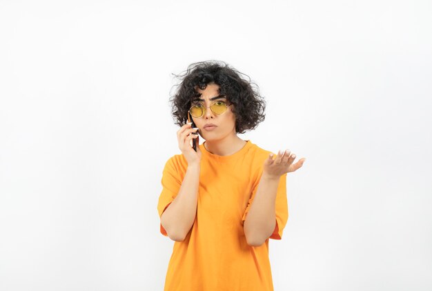Foto de mujer rizada hablando por teléfono