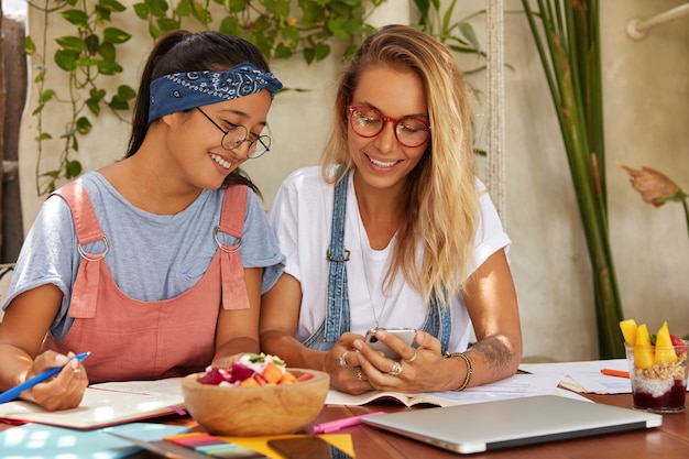 Foto de mujeres felices de diferentes razas riendo mientras mira un video divertido en el sitio web de Internet