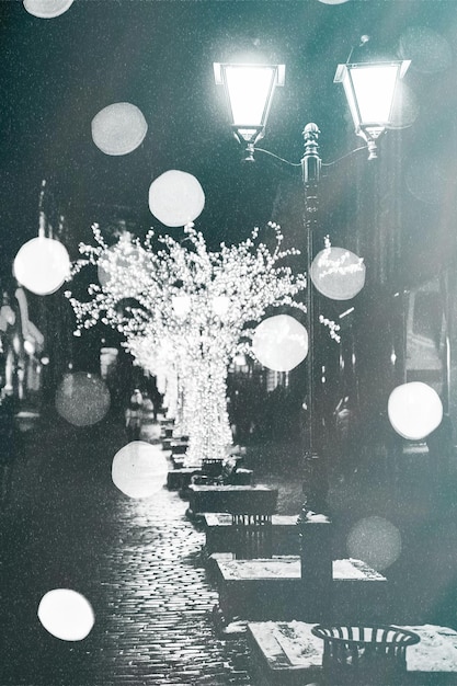 Foto gratuita foto oscura de una farola en una noche de nieve con luces navideñas