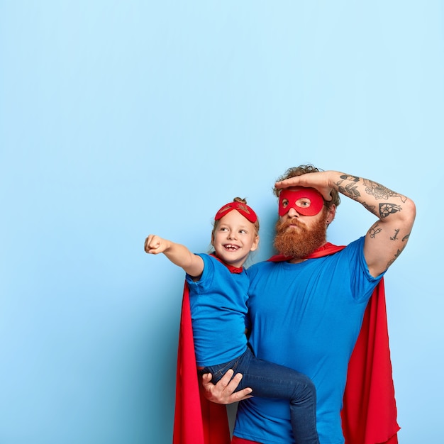 Foto de padre e hija jugando juntos, con disfraces de superhéroe