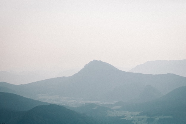 Foto de paisaje de una montaña neblinosa con un cielo sombrío en el fondo