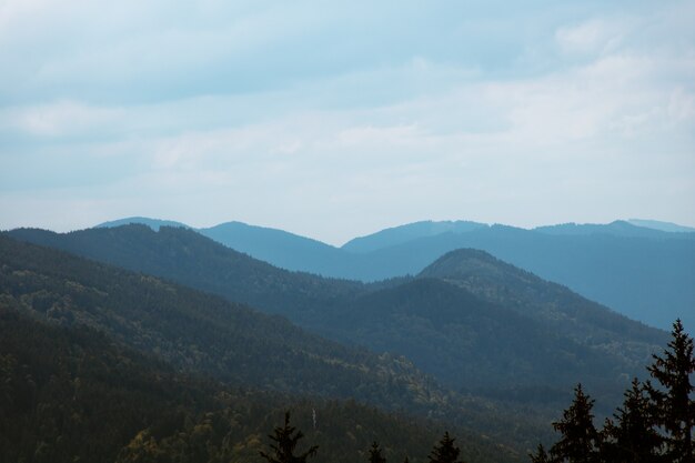 Foto de paisaje de montañas azules con un nublado cielo sombrío