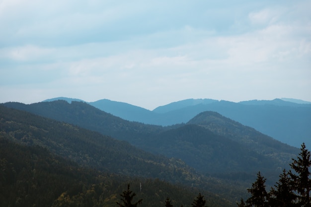 Foto de paisaje de montañas azules con un nublado cielo sombrío