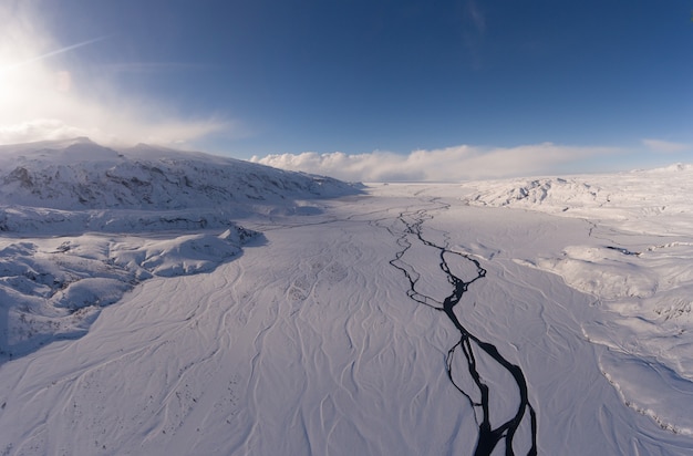 Foto de paisaje de montañas nevadas bajo un cielo nublado durante el día