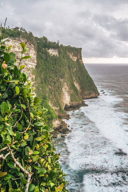 Foto panorámica de los acantilados de Uluwatu en Bali, Indonesia, bajo un cielo nublado