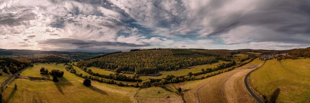 Foto panorámica de campos agrícolas bajo la luz del sol y un cielo nublado en el campo