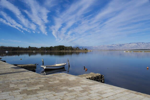 Foto panorámica fascinante de un gran lago bajo un cielo azul con corrientes de nubes