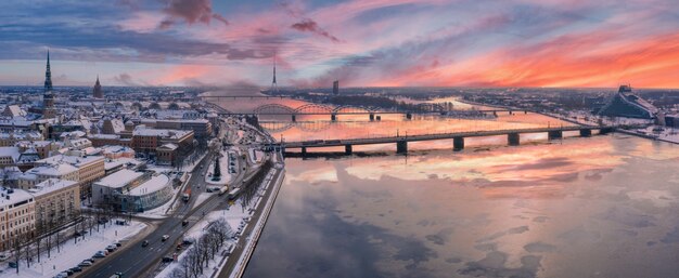 Foto panorámica de la hermosa puesta de sol sobre la ciudad de Riga cubierta de nieve con el río Daugava y el centro de la ciudad