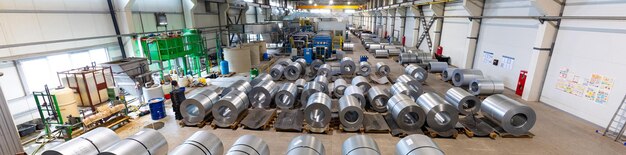 Foto panorámica de la línea de producción de tejas metálicas para techos Máquina formadora de acero en taller de fábrica de carpintería metálica Máquina perfiladora de chapa metálica Fondo de la planta