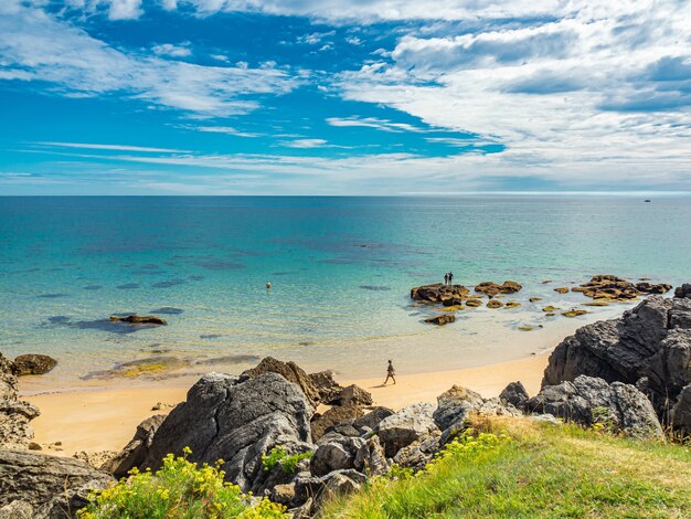 Foto panorámica de una playa blanca rocosa sobre fondo de nubes finas