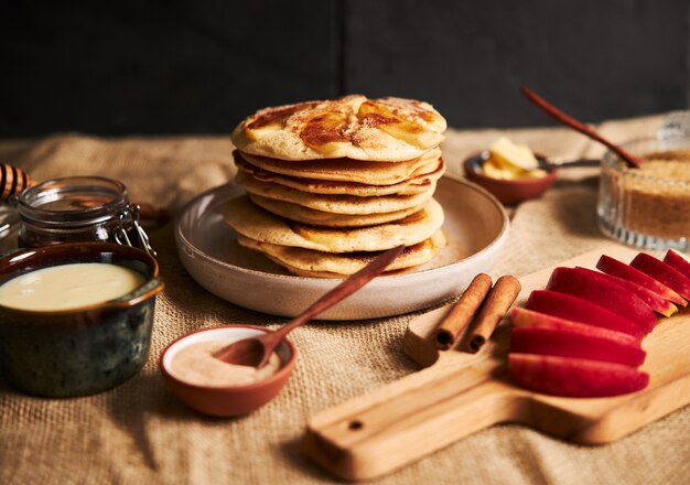 Foto de panqueques de manzana con manzanas y otros ingredientes sobre la mesa