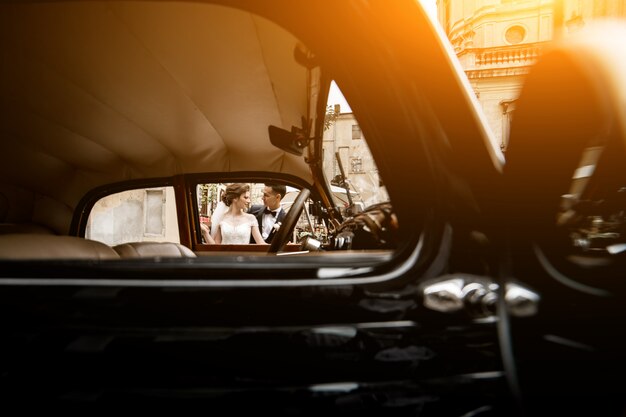 Foto de pareja de boda en coche retro