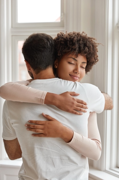 Foto de pareja diversa abrazar unos a otros